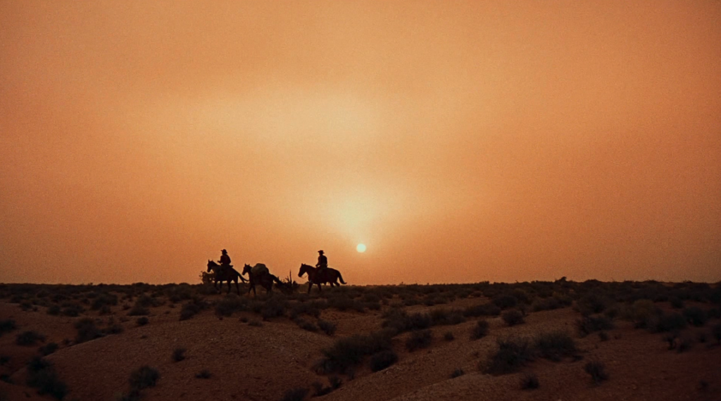 Ethan and Martin ride across the horizon on their long journey.